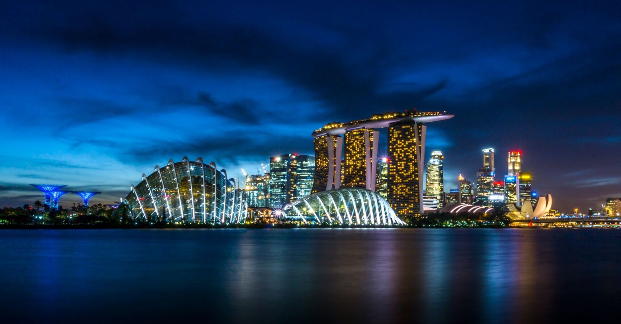 Singapore skyline at night featuring Marina Bay Sands and Gardens by the Bay