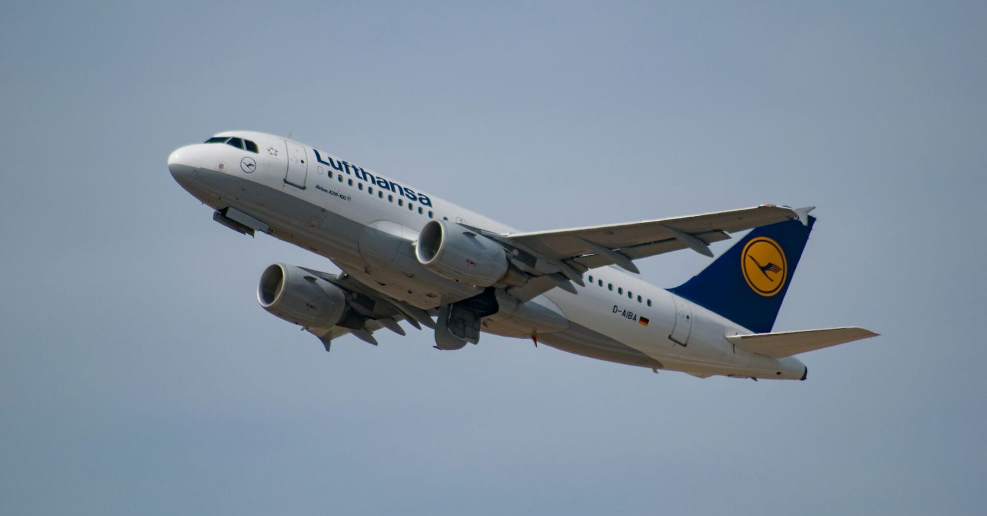 A Lufthansa aircraft taking off against a clear sky