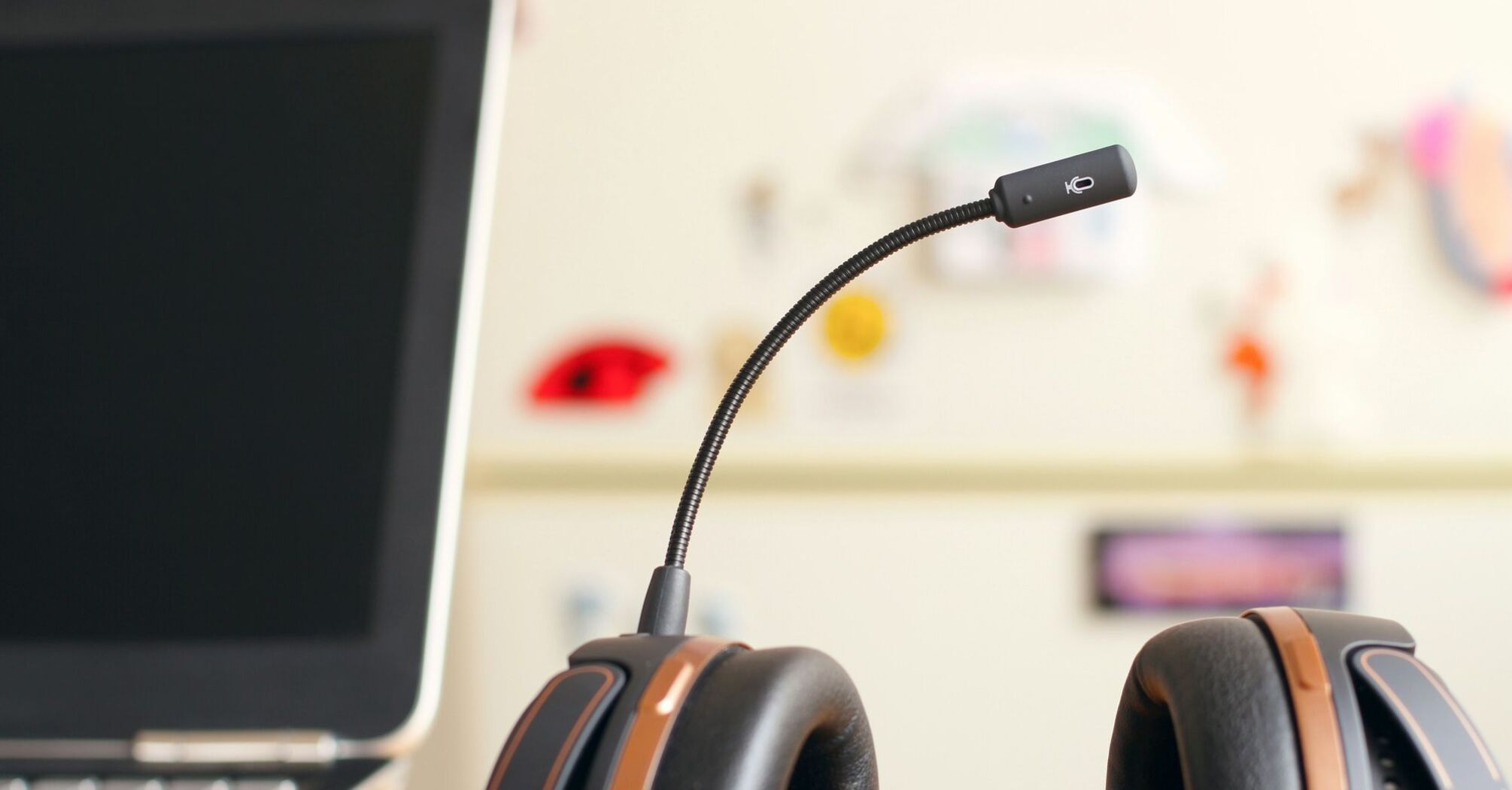 A close-up of a professional headset with a microphone next to a laptop, representing customer service or call center operations