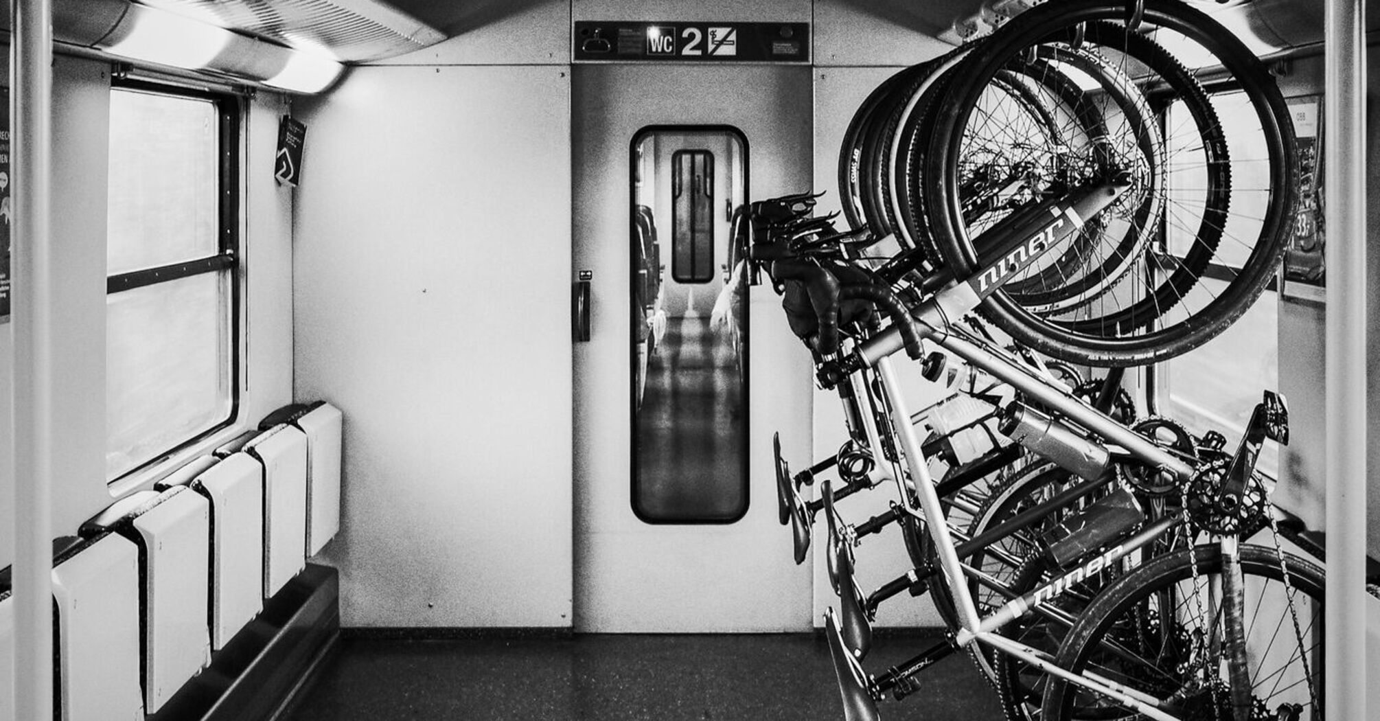 A bicycle storage area inside a train, featuring multiple bikes securely mounted on racks