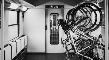 A bicycle storage area inside a train, featuring multiple bikes securely mounted on racks