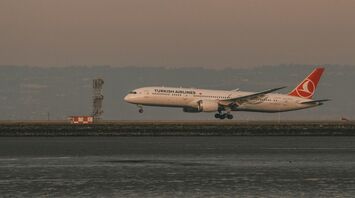 Turkish Airlines aircraft landing at an international airport during sunset