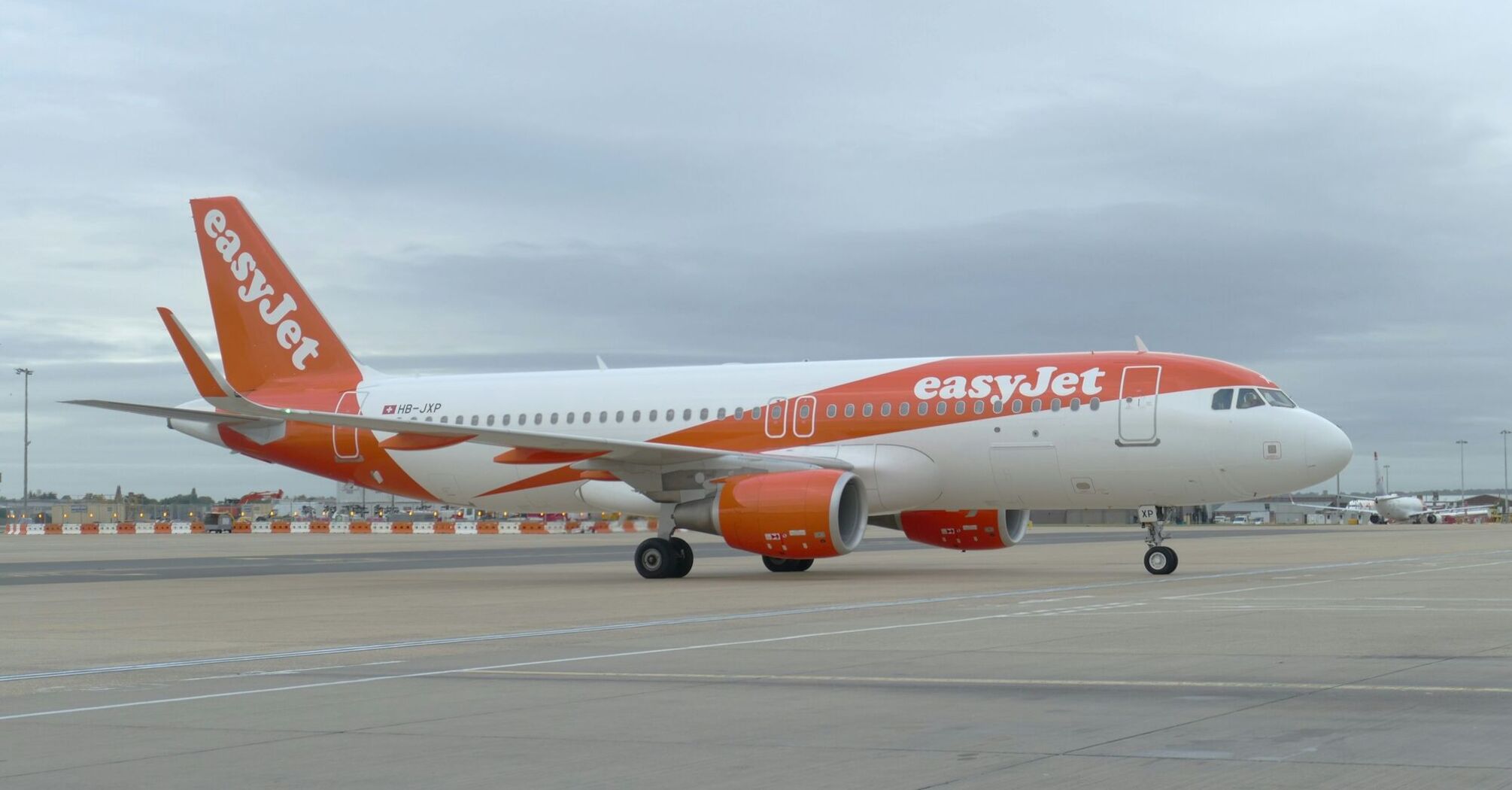 easyJet plane taxiing at an airport under cloudy skies