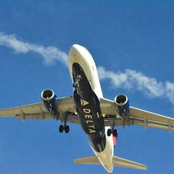 Delta Air Lines aircraft ascending with a clear blue sky