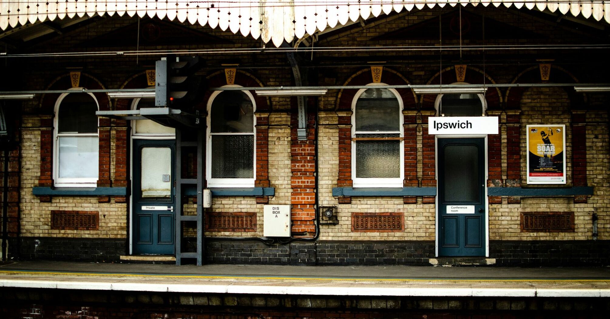 Ipswich railway station platform with historic brick architecture and signage