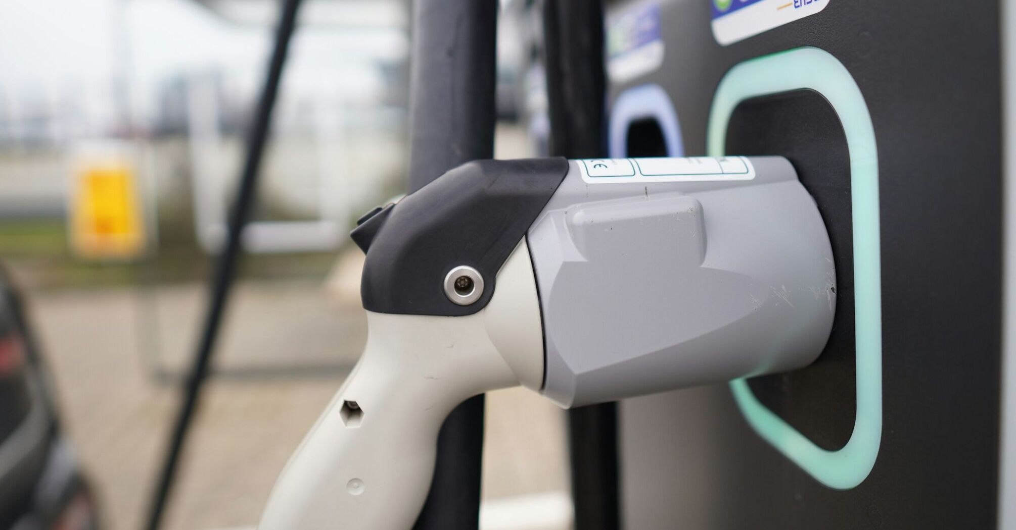 Close-up of an electric vehicle charging plug connected to a station