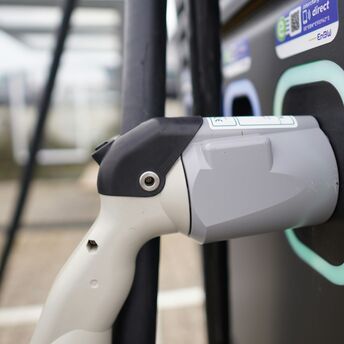 Close-up of an electric vehicle charging plug connected to a station