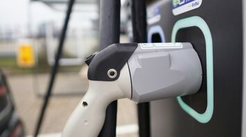 Close-up of an electric vehicle charging plug connected to a station