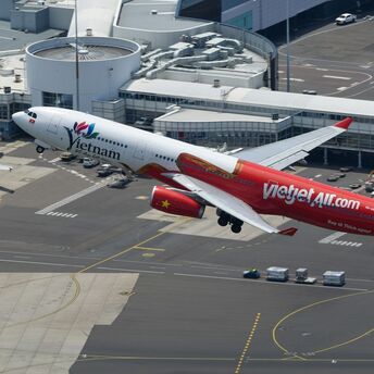 Vietjet aircraft taking off from an international airport, showcasing its red and white livery