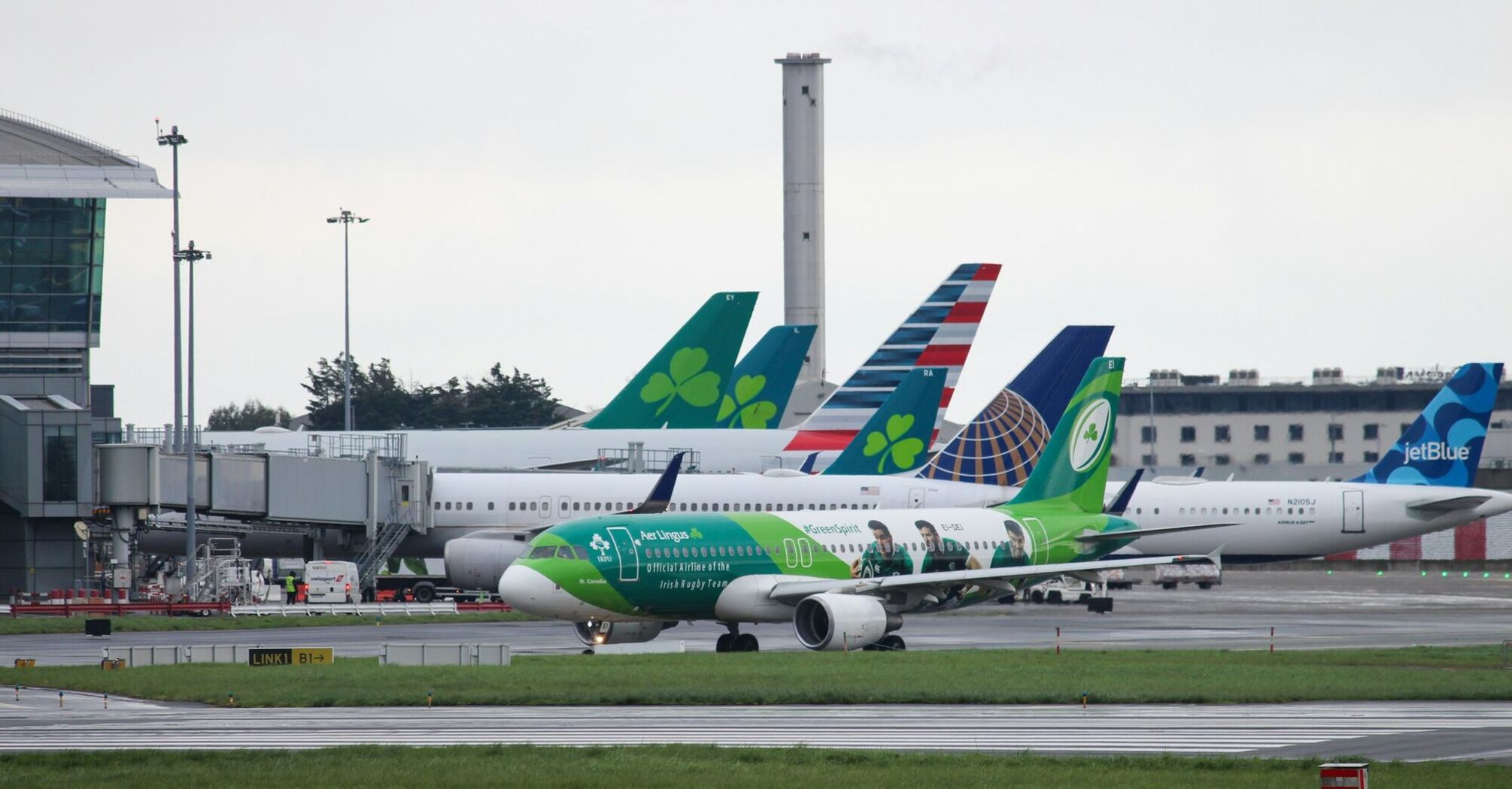 Aer Lingus aircraft taxiing at Dublin Airport with multiple airline tails in the background