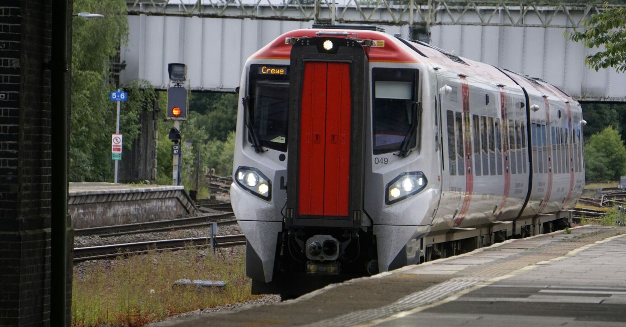 A modern passenger train at a station platform, preparing for departure