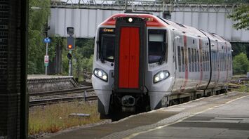 A modern passenger train at a station platform, preparing for departure