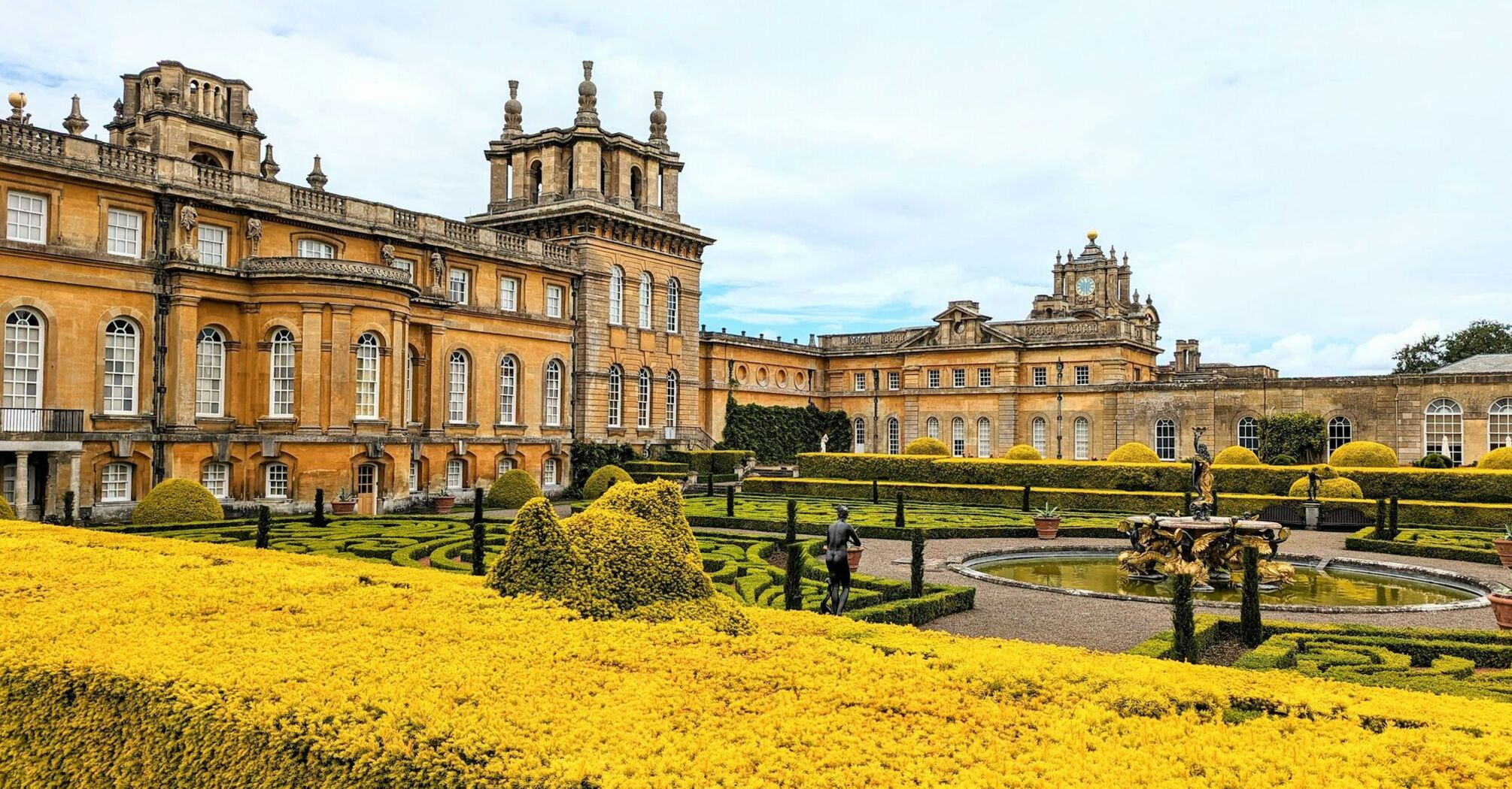 Historic Blenheim Palace with landscaped gardens and ornate fountains in springtime