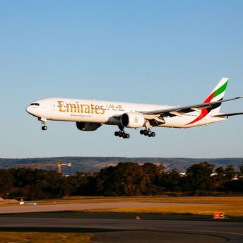Emirates Boeing 777-300ER landing at an airport during golden hour