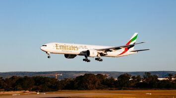Emirates Boeing 777-300ER landing at an airport during golden hour