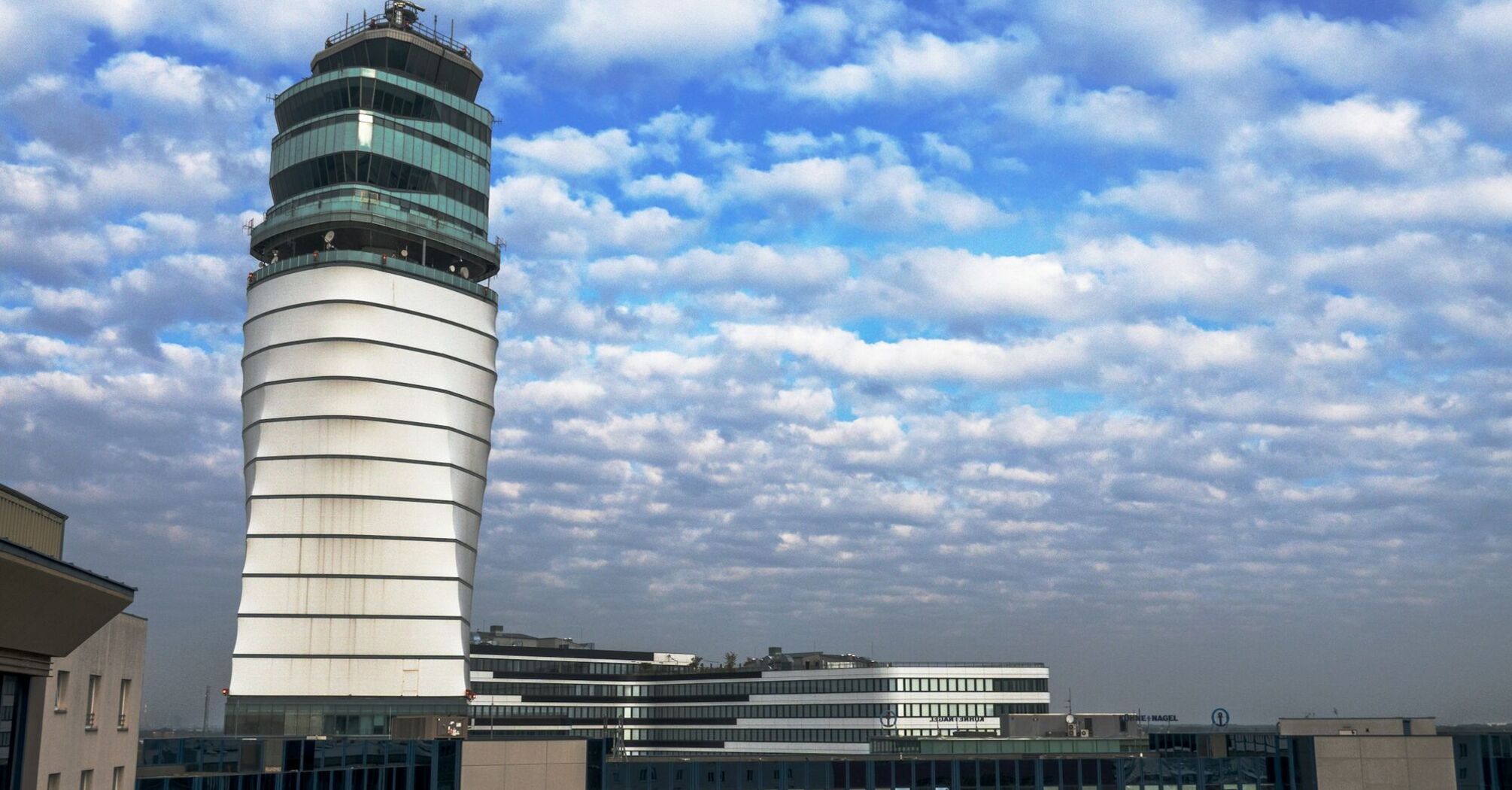 Vienna Airport's modern control tower under a partly cloudy sky