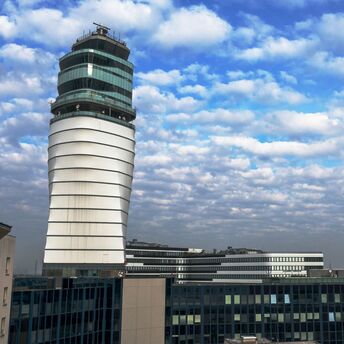 Vienna Airport's modern control tower under a partly cloudy sky