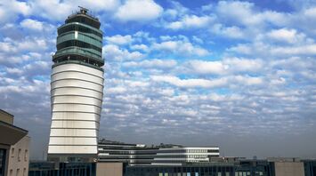 Vienna Airport's modern control tower under a partly cloudy sky