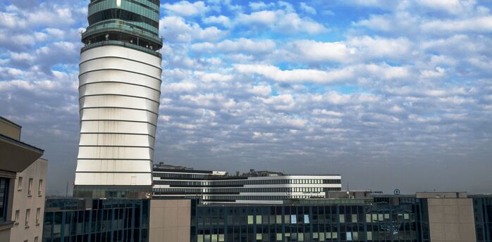 Vienna Airport's modern control tower under a partly cloudy sky