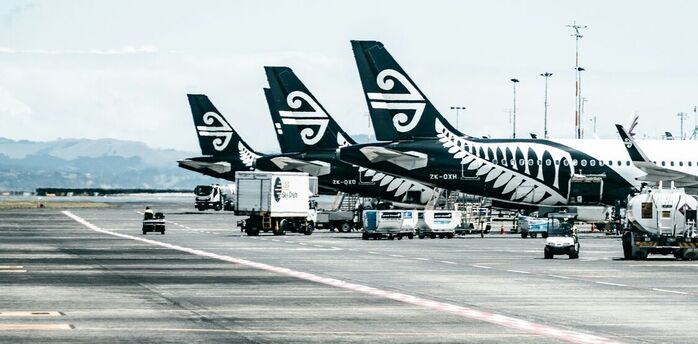 Air New Zealand aircraft lined up at the airport with ground services in operation