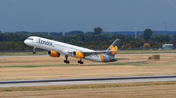 A Condor aircraft taking off from a runway under a cloudy sky