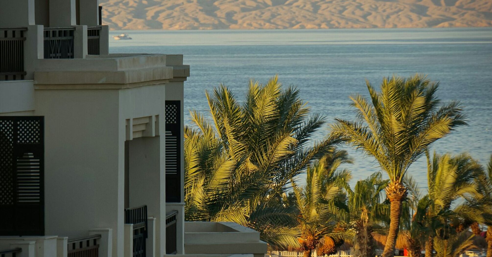 A seaside resort in Hurghada, Egypt, with palm trees and a view of the Red Sea and distant mountains in the background