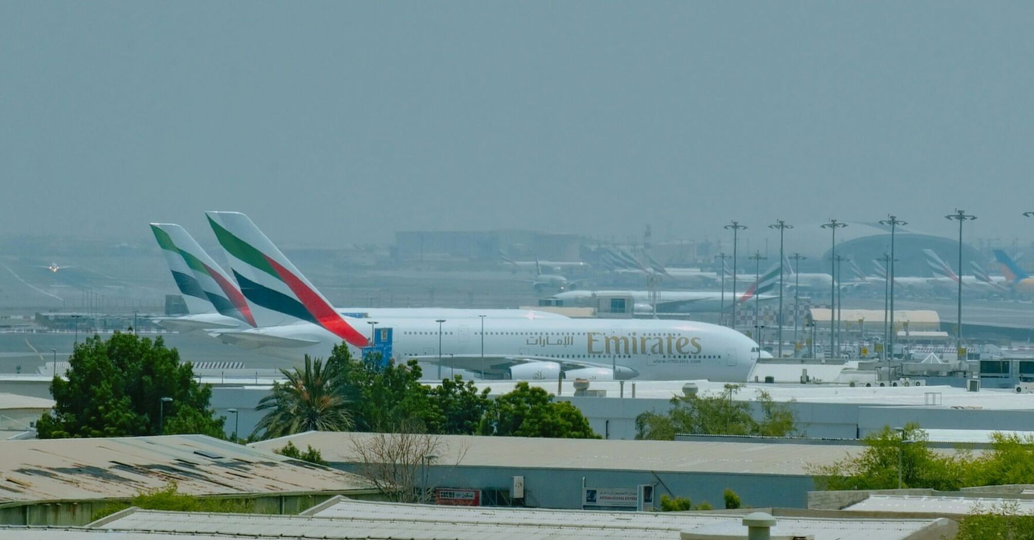 Emirates aircraft parked at Dubai International Airport during daytime