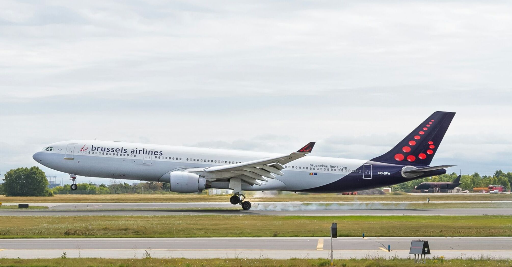 Brussels Airlines aircraft landing on runway with smoke from tires