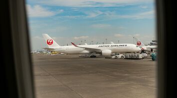 View of Japan Airlines aircraft through airplane window at airport