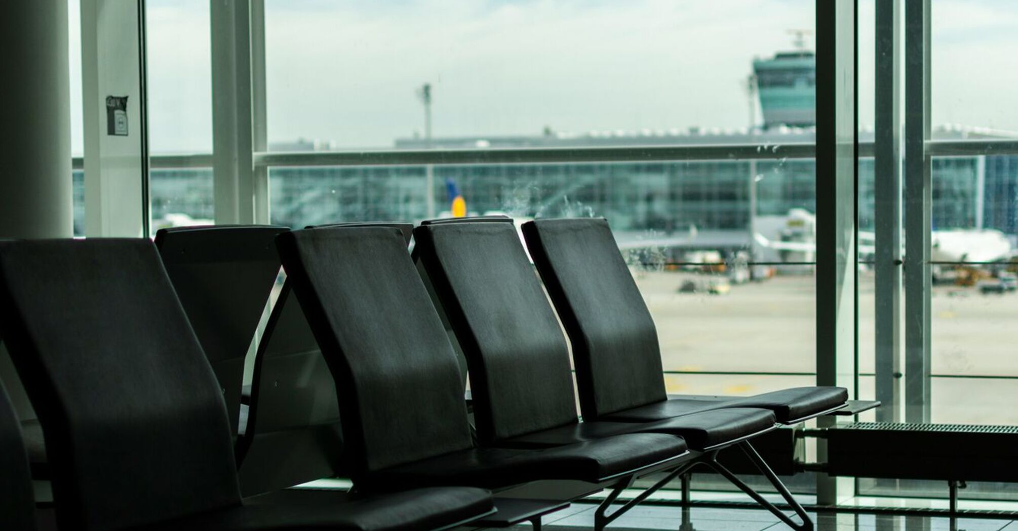 Empty airport seating area with view of terminal and aircraft in the background