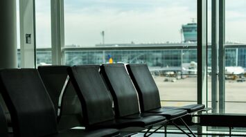 Empty airport seating area with view of terminal and aircraft in the background