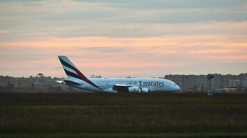 Emirates A380 aircraft taxiing at Sydney Airport during sunset