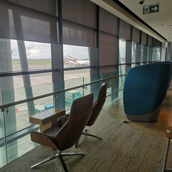 Seating area inside Dublin Airport lounge overlooking runway with international aircraft in view