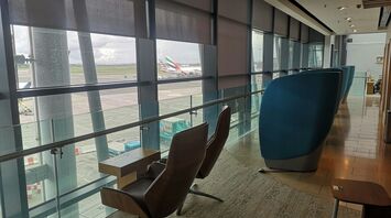 Seating area inside Dublin Airport lounge overlooking runway with international aircraft in view