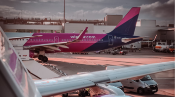 Wizz Air aircraft parked at the gate with jet engine in foreground