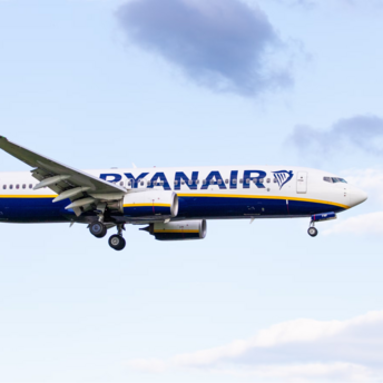 Ryanair airplane in mid-flight against a blue sky