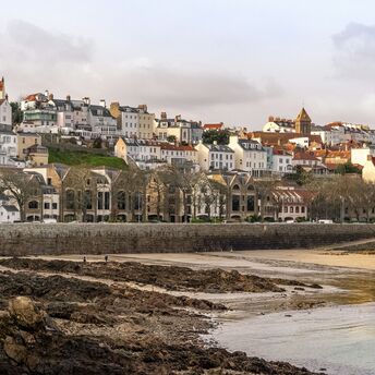 Coastal view of St Peter Port in Guernsey with historic buildings overlooking the waterfront