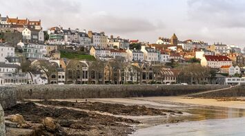Coastal view of St Peter Port in Guernsey with historic buildings overlooking the waterfront
