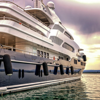 Luxury yacht docked on calm water at sunset