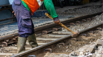 Rail worker using a sledgehammer during track maintenance