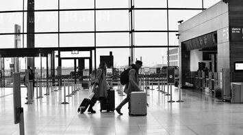 Travelers with suitcases walking through a modern airport terminal