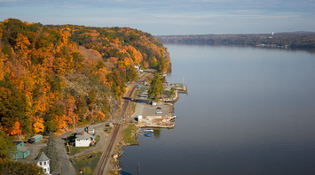 Aerial view of the Hudson River with fall foliage and a small riverside area