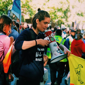 Woman holding megaphone at a public protest during a strike