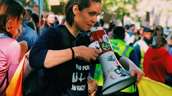 Woman holding megaphone at a public protest during a strike