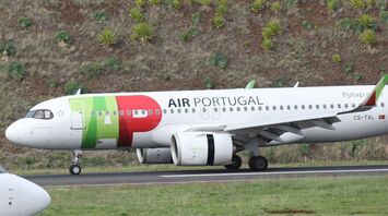 TAP Air Portugal aircraft taxiing on runway near hillside