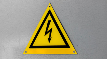 High voltage warning sign on a grey wall