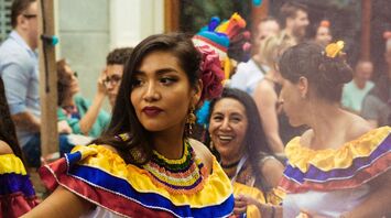 Woman in traditional Latin American dress dancing during a cultural celebration