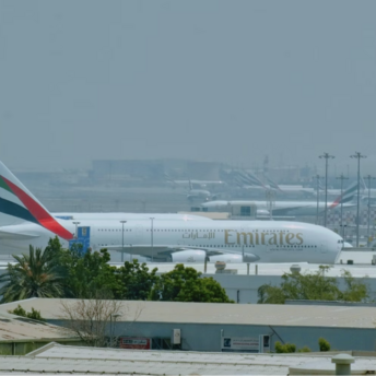 Emirates aircraft parked at Dubai International Airport on a hazy day