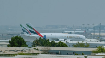 Emirates aircraft parked at Dubai International Airport on a hazy day