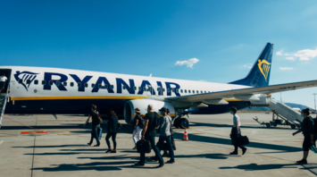 Passengers boarding a Ryanair aircraft at the airport on a sunny day